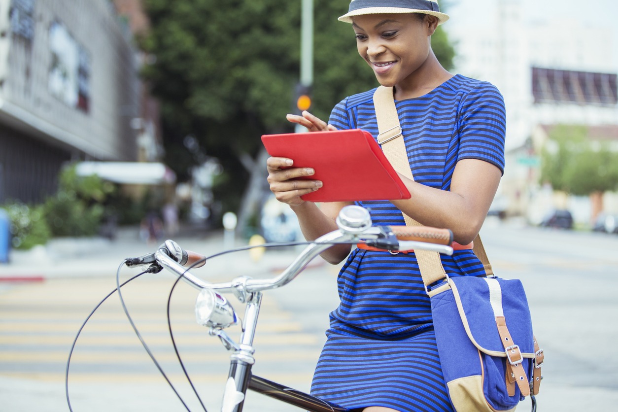 A woman on a bicycle wearing a messenger bag