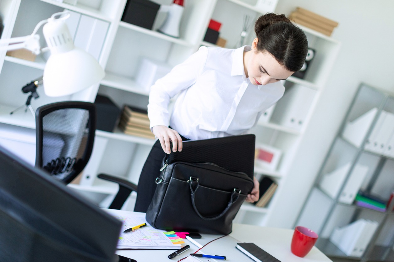 An office girl putting things in a bag