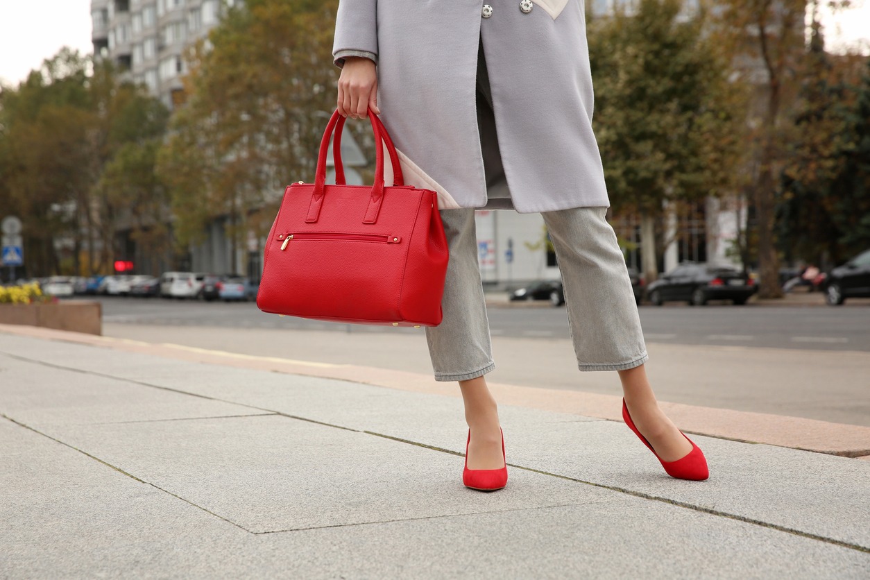 Stylish woman with trendy leather bag on city street, closeup